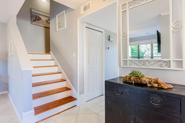 staircase featuring tile patterned flooring and visible vents
