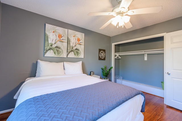 bedroom featuring ceiling fan, a textured ceiling, a closet, and wood finished floors