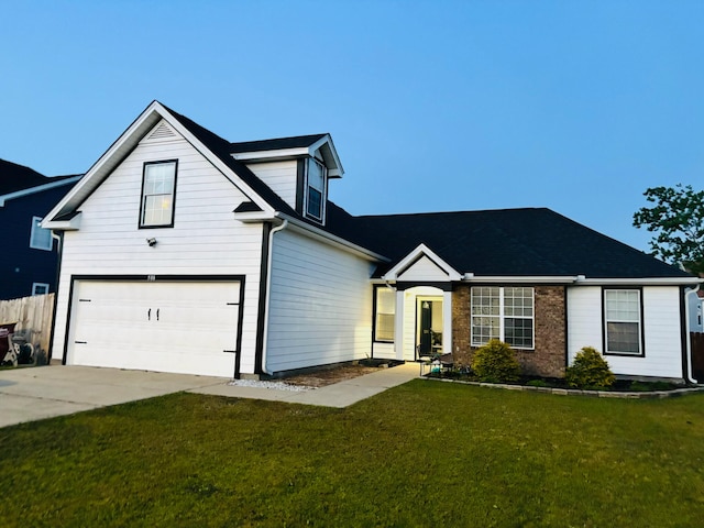 view of front of home featuring an attached garage, driveway, and a front yard