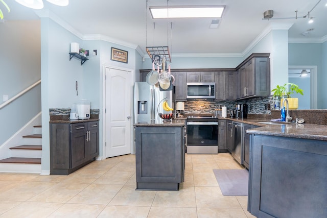 kitchen with dark brown cabinetry, a kitchen island, tasteful backsplash, a sink, and stainless steel appliances