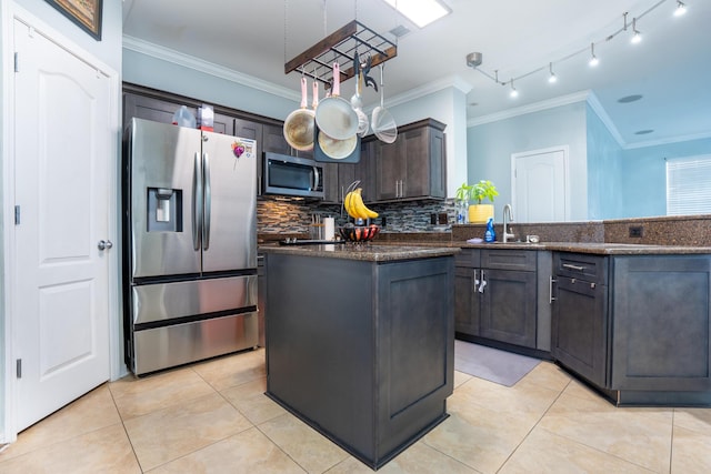 kitchen featuring ornamental molding, stainless steel appliances, a peninsula, and tasteful backsplash