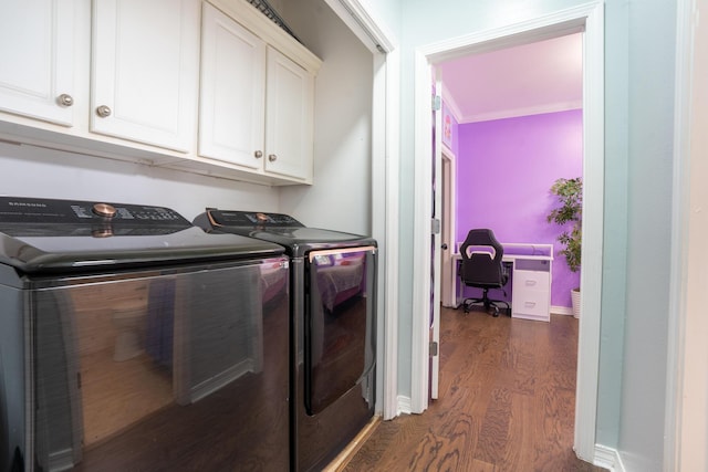 laundry area featuring washer and clothes dryer, cabinet space, and dark wood-type flooring