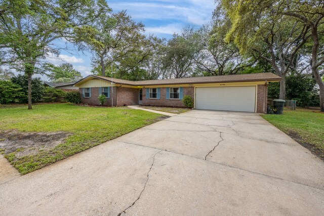 ranch-style house featuring brick siding, a garage, a front lawn, and concrete driveway