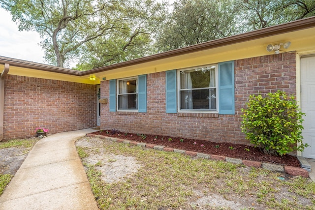 doorway to property featuring brick siding