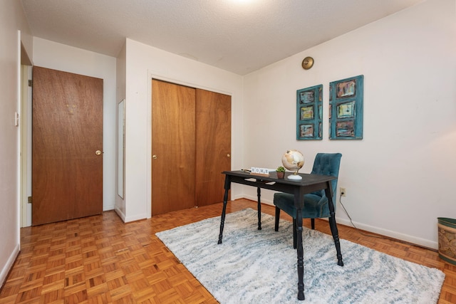 home office featuring baseboards and a textured ceiling