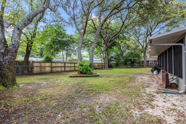 view of yard with a fenced backyard and a sunroom