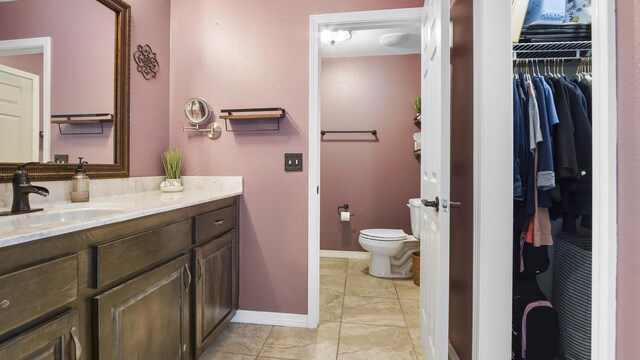 199 W Italian Ave, Defuniak Springs, FL 32433 - bathroom featuring vanity, toilet, baseboards, and a walk in closet