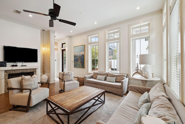 living room featuring crown molding, recessed lighting, light wood-type flooring, and visible vents