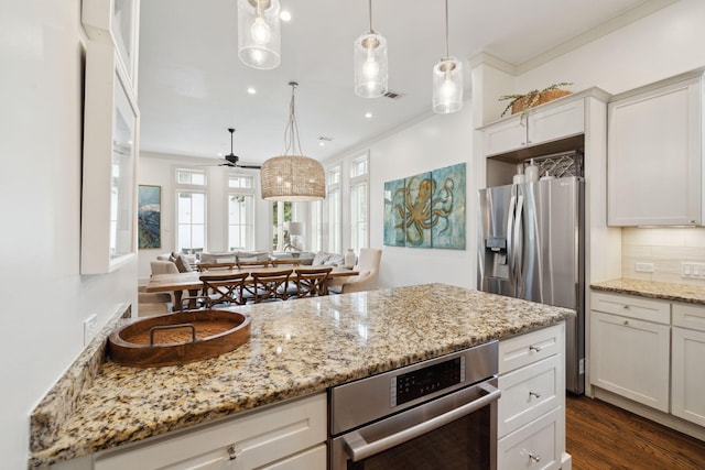 kitchen featuring plenty of natural light, decorative backsplash, crown molding, and stainless steel appliances