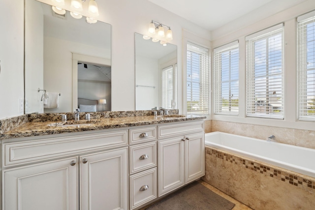 bathroom featuring double vanity, tile patterned floors, a sink, and a garden tub
