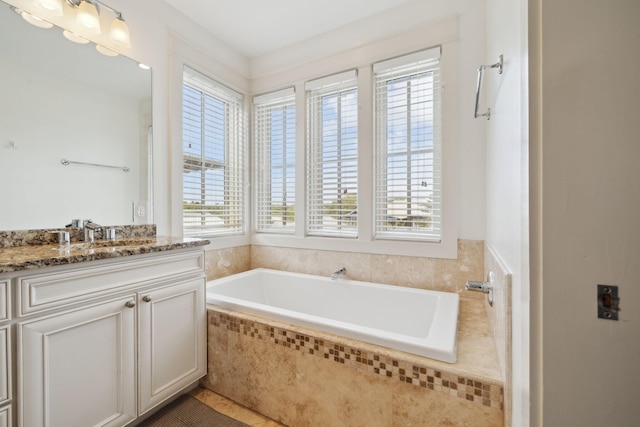 bathroom featuring a garden tub and vanity