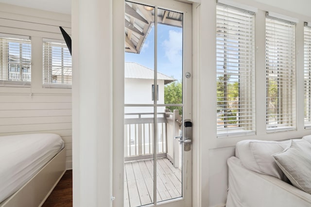 bedroom featuring access to outside, wood finished floors, and multiple windows