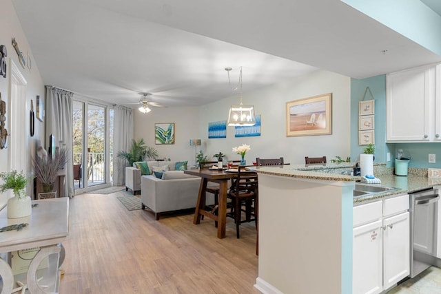 kitchen with stainless steel dishwasher, light wood-type flooring, white cabinets, a peninsula, and open floor plan
