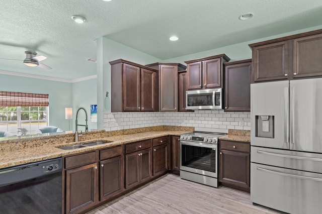 114 Rearden Way, Santa Rosa Beach, FL 32459 - kitchen with stainless steel appliances, a sink, a textured ceiling, light stone countertops, and dark brown cabinetry