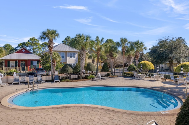 community pool with fence and a patio area