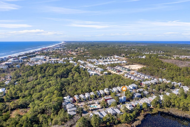 aerial view of property and surrounding area featuring a nearby body of water and a forest