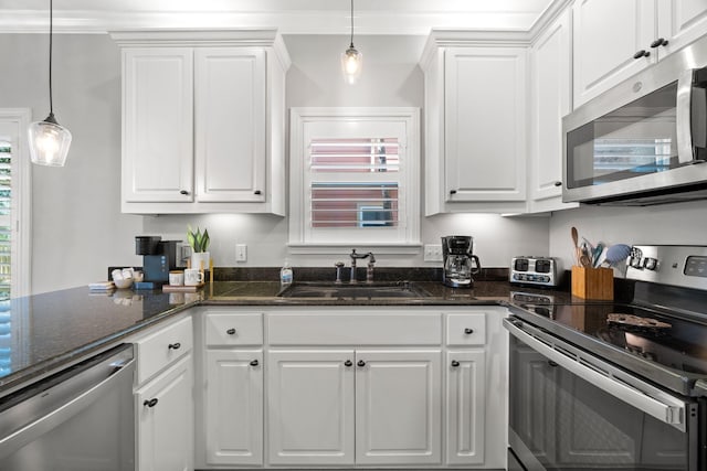 kitchen featuring stainless steel appliances, a sink, white cabinets, and hanging light fixtures