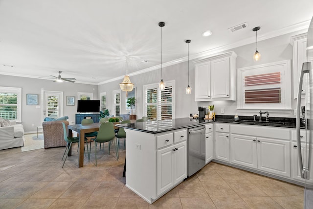kitchen featuring stainless steel appliances, open floor plan, a sink, dark countertops, and a peninsula