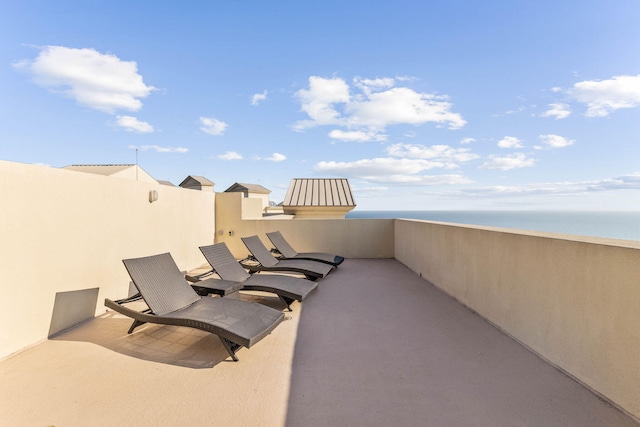 view of patio featuring a water view and a balcony