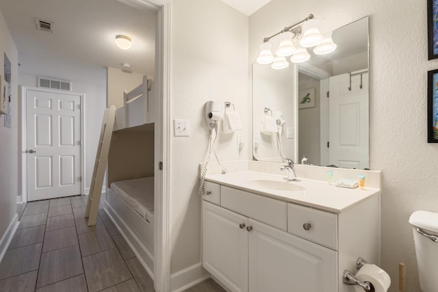16819 Front Beach Rd Unit 1114, Panama City Beach, FL 32413 - bathroom with vanity, toilet, baseboards, and a textured wall