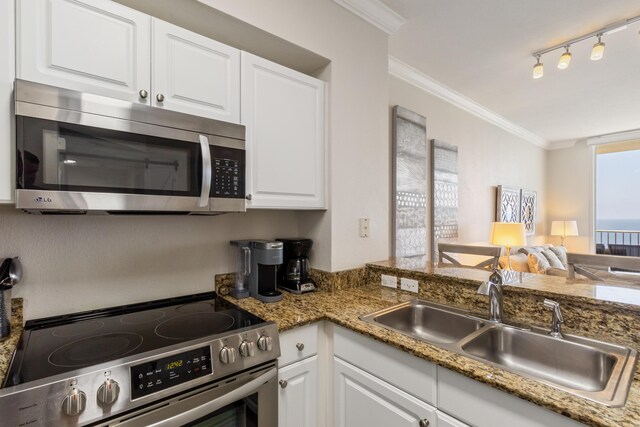 16819 Front Beach Rd Unit 2415, Panama City Beach, FL 32413 - kitchen featuring stainless steel appliances, a sink, white cabinets, ornamental molding, and open floor plan