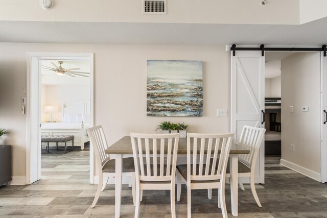 16819 Front Beach Rd Unit 2415, Panama City Beach, FL 32413 - dining room featuring light wood-style floors, baseboards, a barn door, and ceiling fan