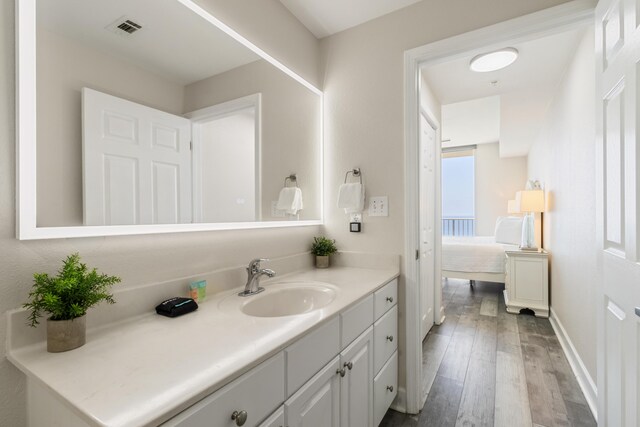 16819 Front Beach Rd Unit 2415, Panama City Beach, FL 32413 - bathroom with wood finished floors, vanity, connected bathroom, and baseboards