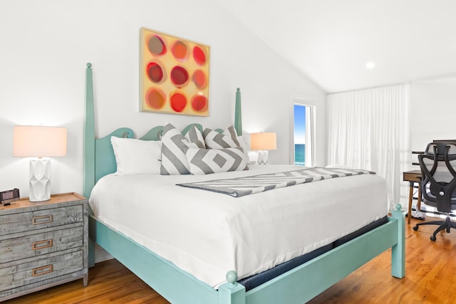 bedroom with lofted ceiling and wood finished floors