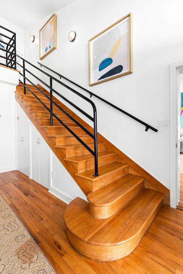 stairway with baseboards and wood finished floors