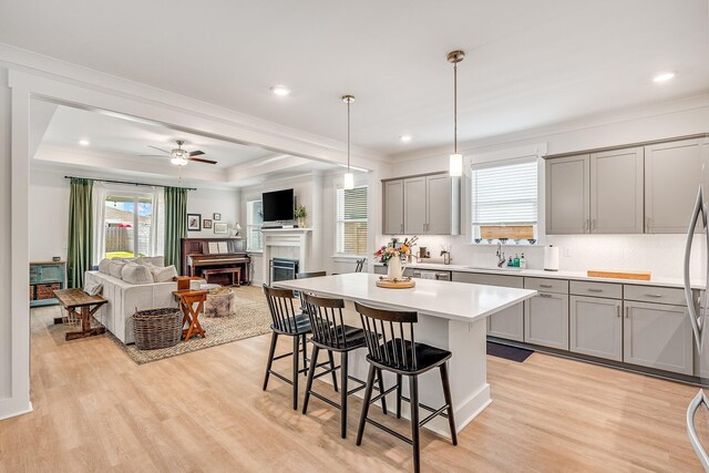 2108 Royal Tern St, Panama City, FL 32405 - kitchen featuring gray cabinets, a fireplace, a sink, a breakfast bar, and light wood-style flooring