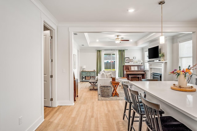2108 Royal Tern St, Panama City, FL 32405 - kitchen featuring a ceiling fan, a tiled fireplace, a kitchen breakfast bar, and light wood finished floors