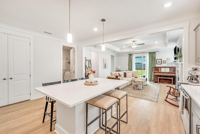2108 Royal Tern St, Panama City, FL 32405 - kitchen with visible vents, a breakfast bar area, light wood-type flooring, light countertops, and a tray ceiling