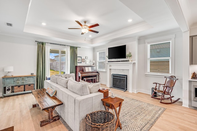 2108 Royal Tern St, Panama City, FL 32405 - living area featuring a raised ceiling, a fireplace, a ceiling fan, and light wood-style flooring