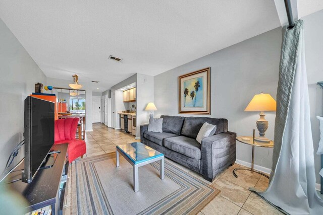 7453 Sunset Harbor Dr Apt 2-204, Navarre, FL 32566 - living room with visible vents, baseboards, and light tile patterned flooring