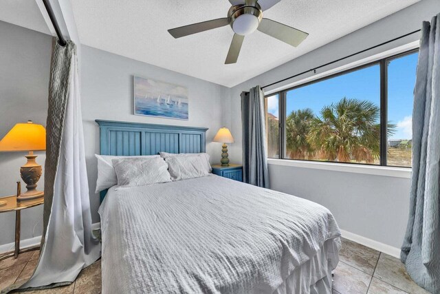7453 Sunset Harbor Dr Apt 2-204, Navarre, FL 32566 - bedroom featuring a textured ceiling, baseboards, and a ceiling fan