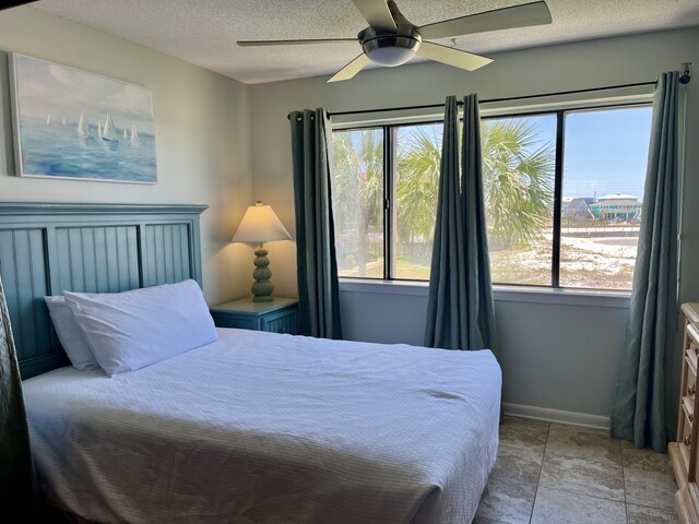 7453 Sunset Harbor Dr Apt 2-204, Navarre, FL 32566 - bedroom featuring a textured ceiling, baseboards, and a ceiling fan