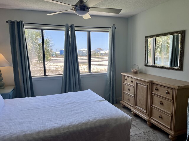 7453 Sunset Harbor Dr Apt 2-204, Navarre, FL 32566 - bedroom with multiple windows, a textured ceiling, and a ceiling fan