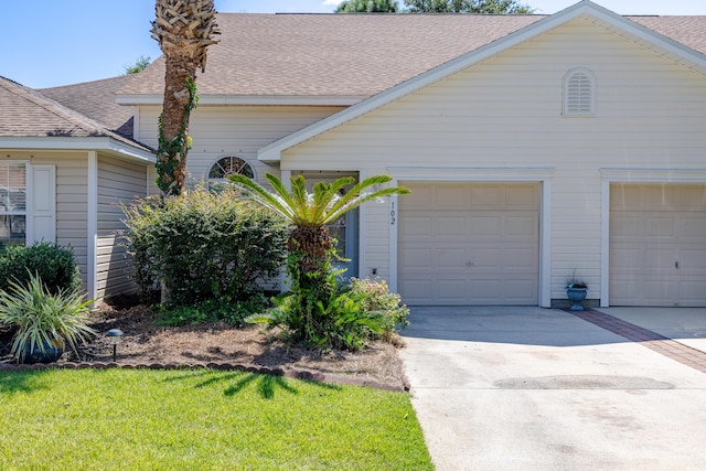 ranch-style house with concrete driveway and a shingled roof