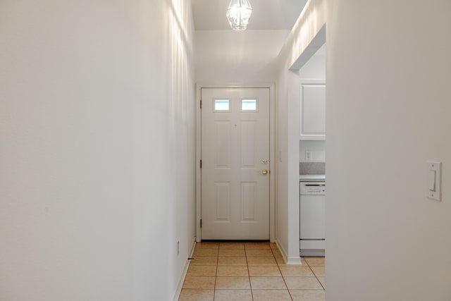 doorway to outside featuring light tile patterned floors and baseboards