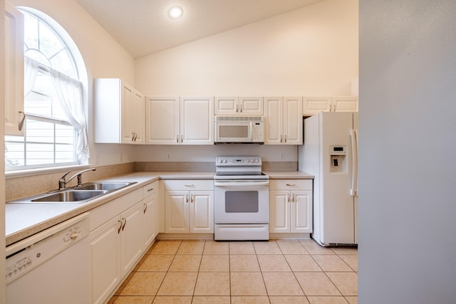kitchen with light tile patterned floors, high vaulted ceiling, a sink, white appliances, and light countertops