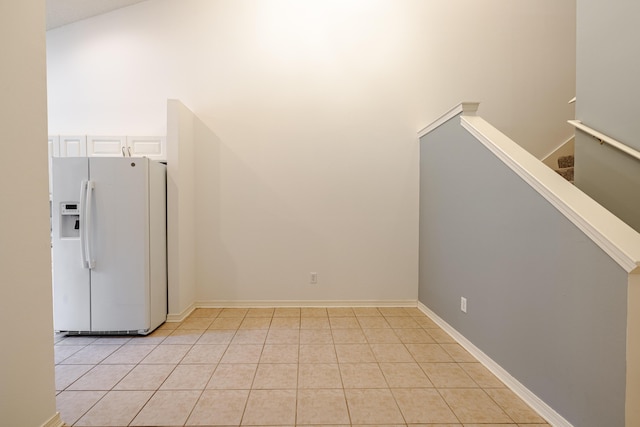 unfurnished room with stairs and light tile patterned floors