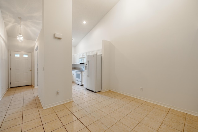 entryway with baseboards, light tile patterned flooring, and high vaulted ceiling