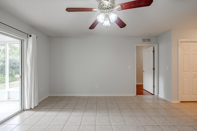 spare room with ceiling fan, baseboards, light tile patterned floors, and visible vents