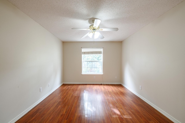 spare room with a ceiling fan, baseboards, a textured ceiling, and wood finished floors