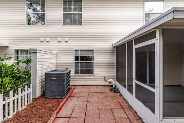 view of patio featuring a sunroom, fence, and central AC
