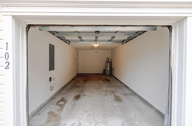 garage with baseboards, secured water heater, and electric panel