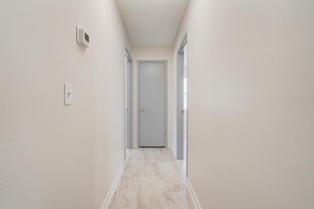 hall with baseboards and marble finish floor