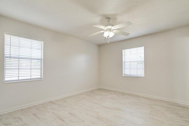 spare room with baseboards and ceiling fan