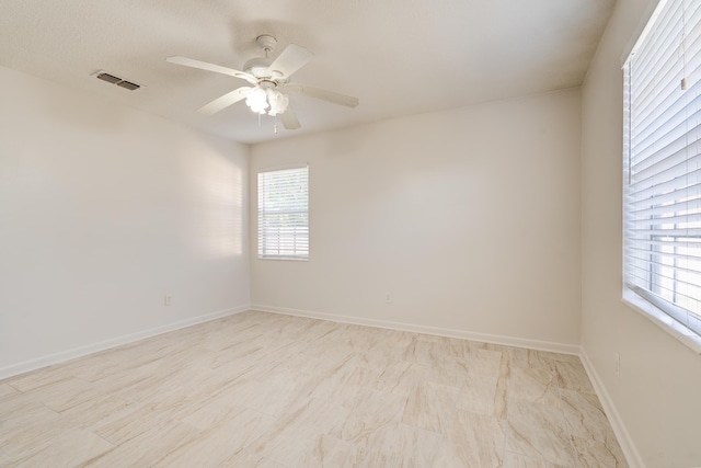 unfurnished room featuring visible vents, baseboards, and ceiling fan