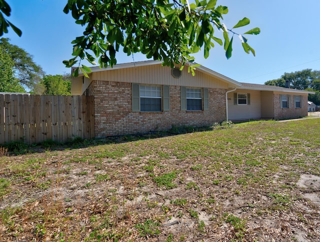 view of front of home featuring fence and brick siding
